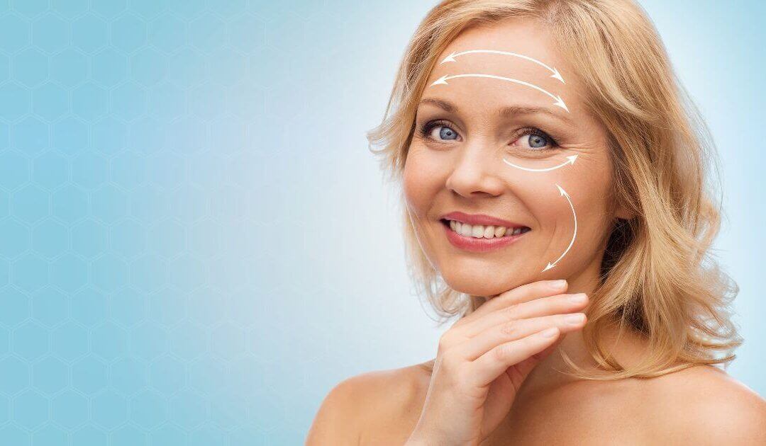 A woman with blonde hair smiles at the camera, embodying the transformative appearance often sought after in facelift benefits. Overlayed white arrows on her face suggest directions for facial massage. The background is a light blue with a subtle hexagonal pattern.